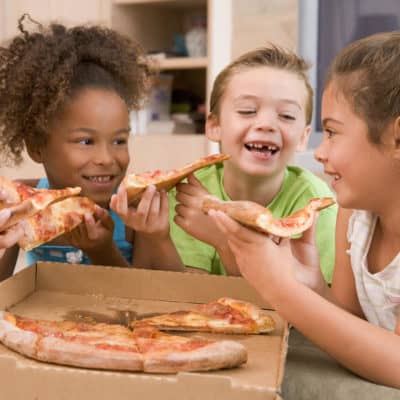 Photo of young kids eating pizza