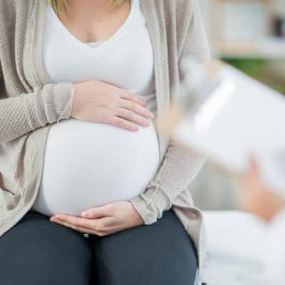 Photo of a pregnant woman holding her belly