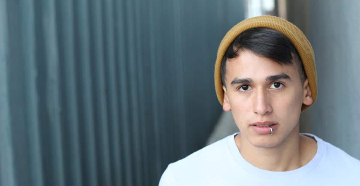 Photo of a young man wearing a beanie looking at camera