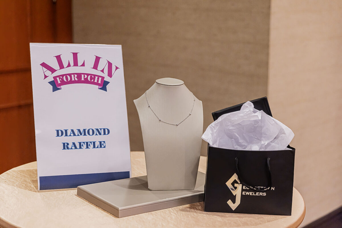Sign reading "Diamond Raffle" Next to necklace on a display neck