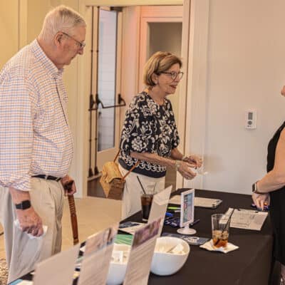 Two people at a table being greeted by Amy Boyle