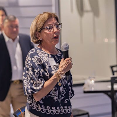 Woman stands holding a microphone