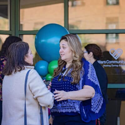 Two women talk in front of a balloon tower