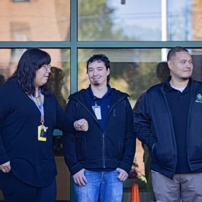 Three people stand up against a wall