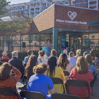 A group of people sit in front of a podium in front of a brick building