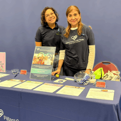 Pillars Community Health Outreach Team tabling at a community event, sharing resources and information with attendees.