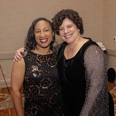 Lanita Higgs Jackson and Angela Curran stand together smiling during the All In for PCH Gala.