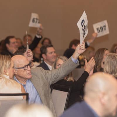 Guests hold up numbered bidding paddles during the paddle raise at the All In for PCH Gala.