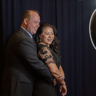 A couple smiles and poses together in front of a photo booth camera during the gala.